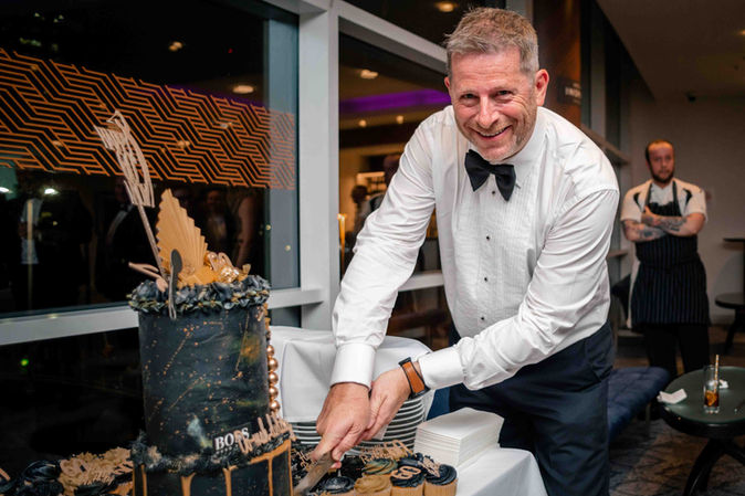 Birthday guest cutting his cake during a milestone celebration at The Lowry Hotel.