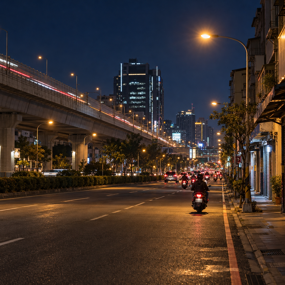 一張從中興路機車道取景的夜間寫實照片,畫面有暖黃路燈、大里市區街屋、軟體園區辦公大樓輪廓,以及74號快速道路的高架橋與車流光軌,適合作為台中外送茶與大里定點茶在地資料比對的配圖