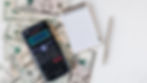 a calculator with cash and a notebook