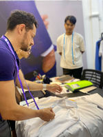 measuring a white shirt during a fitting consultation