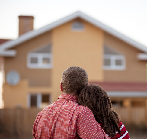 Couple standing in front of house.