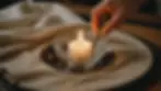 High angle view of a glass candle holder being cleaned with a cloth
