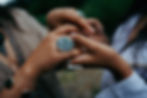Large round pounamu ring held between two hands — a moment of exchange, connection, and natural beauty in handcrafted jewellery.