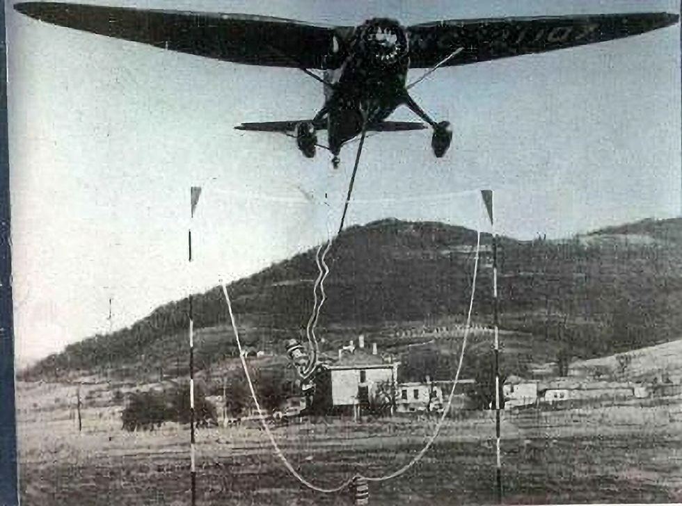 A Stinson Reliant airplane making a mail pickup.