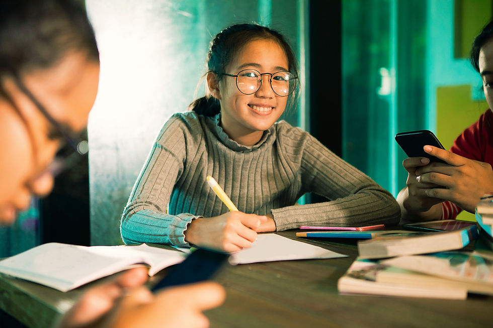 portrait-smiling-teenage-girl-studying-while-sitting-with-friends_edited.jpg
