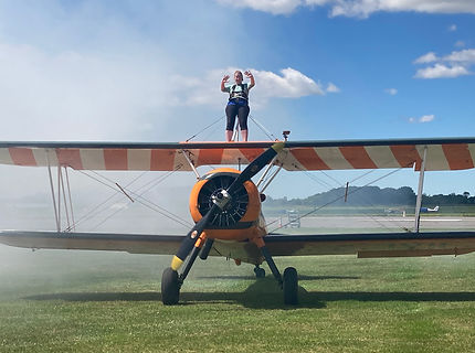 Tessa on top of the wing of a plane after doing a wingwalk