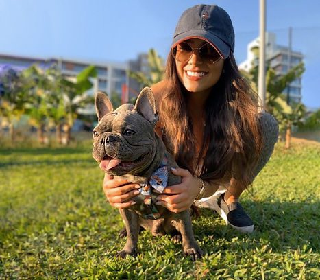 Mulher jovem sorrindo e abraçada em seu Bulldog Francês cinza blue lilac num parque no verão 