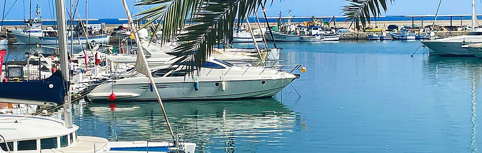 A scenic marina with elegant yachts and sailboats, set against blue skies evoking the lifestyle available to NLV applicants