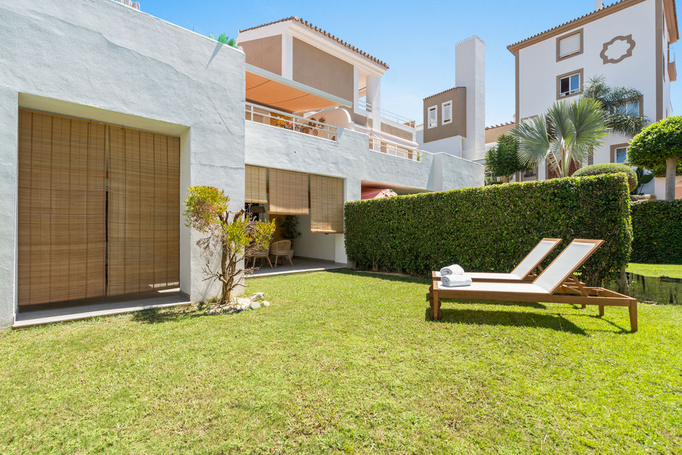 a white house with a lush green lawn in front of it