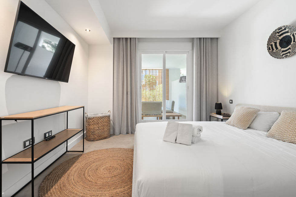 a bedroom with a large bed and a flat screen tv