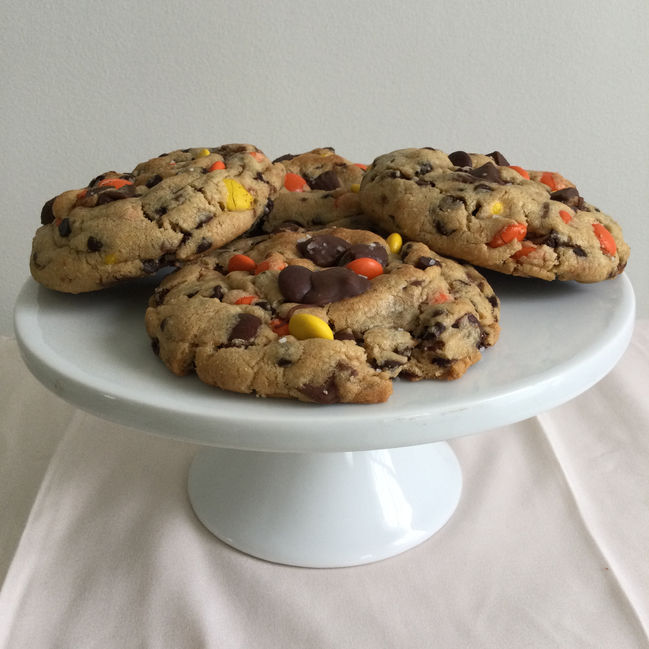 Side view of thick peanut butter cups and Reese's pieces peanut butter cookies