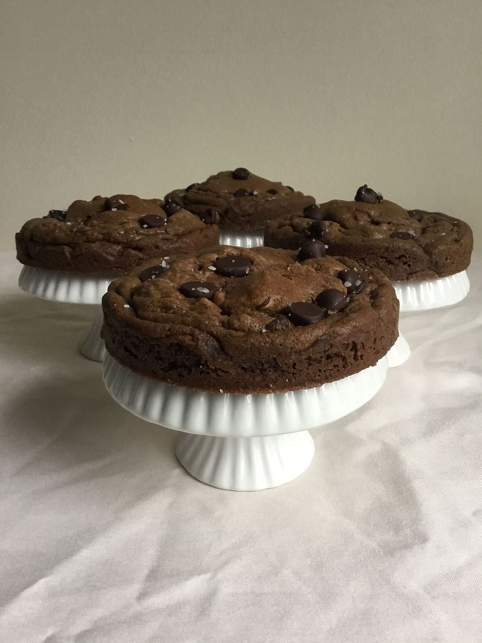 Side view of thick chocolate chocolate chip cookies sprinkled with coarse salt