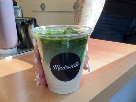 Iced matcha latte being handed off at a Madewell brand activation event with a coffee catering service. 