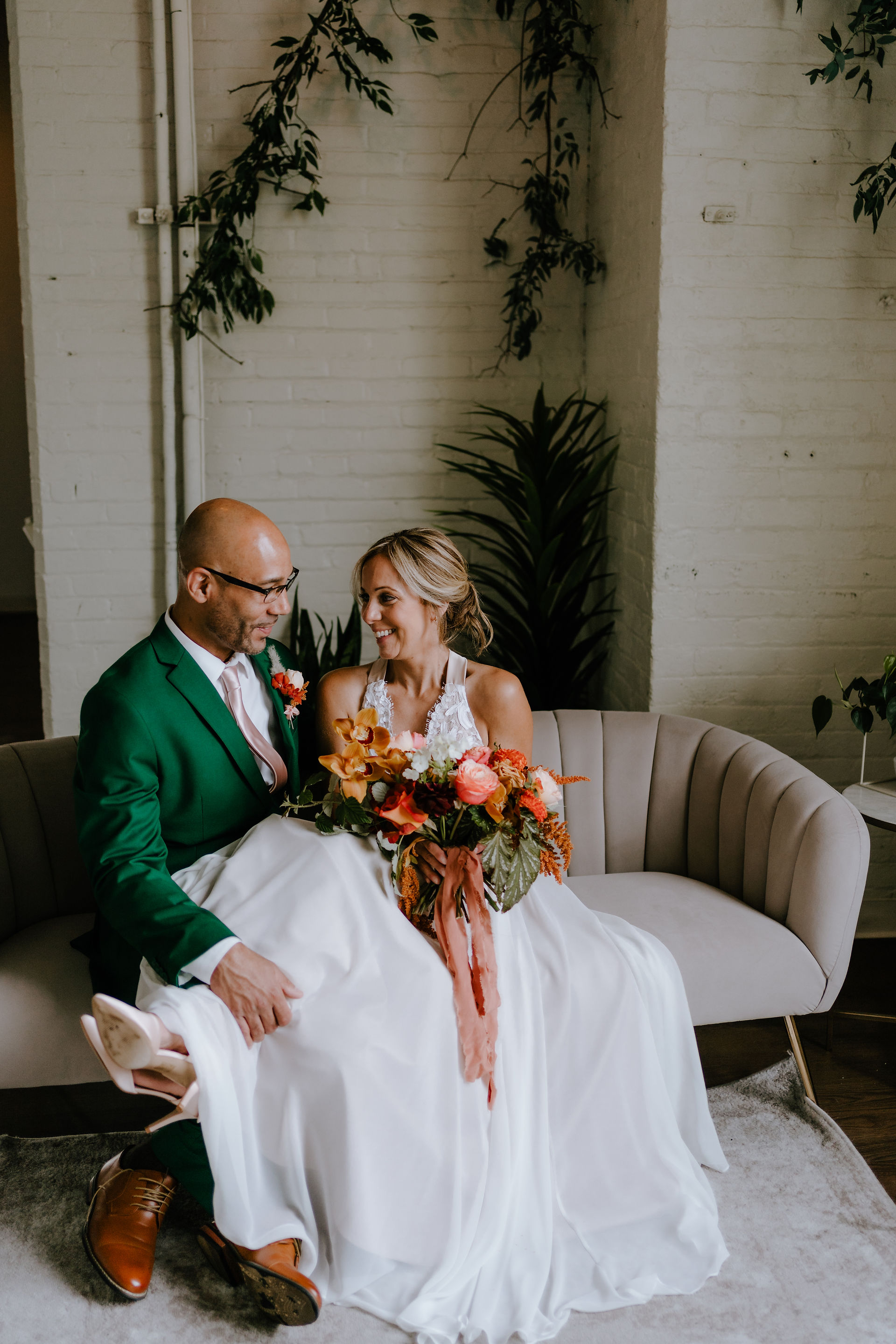 Bride and groom lounging on sofa.