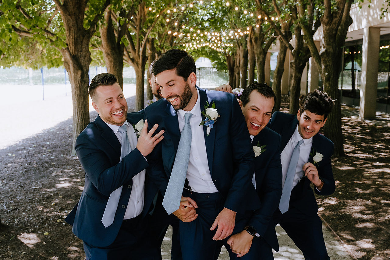 Groom getting tackled by groomsmen.
