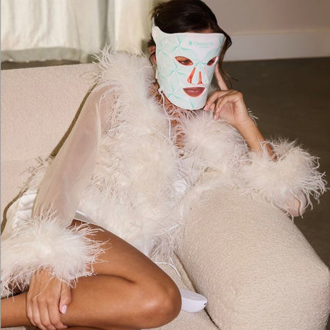 Woman wearing an Omnilux LED light therapy face mask with red light, promoting the Horizon Med Spa blog on LED masks