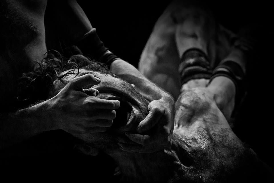 Group of semi-nude performers with bodies painted in white and black, in an intense theatrical scene from Diaries of Hate.