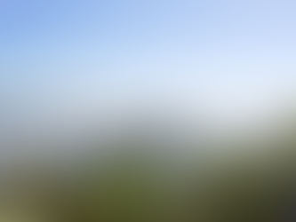 Calm river view from a resident room in the Boardwalk at Victoria Landing, showing a wooden dock extending over the Indian River with still water, greenery, and a distant bridge under a clear blue sky.
