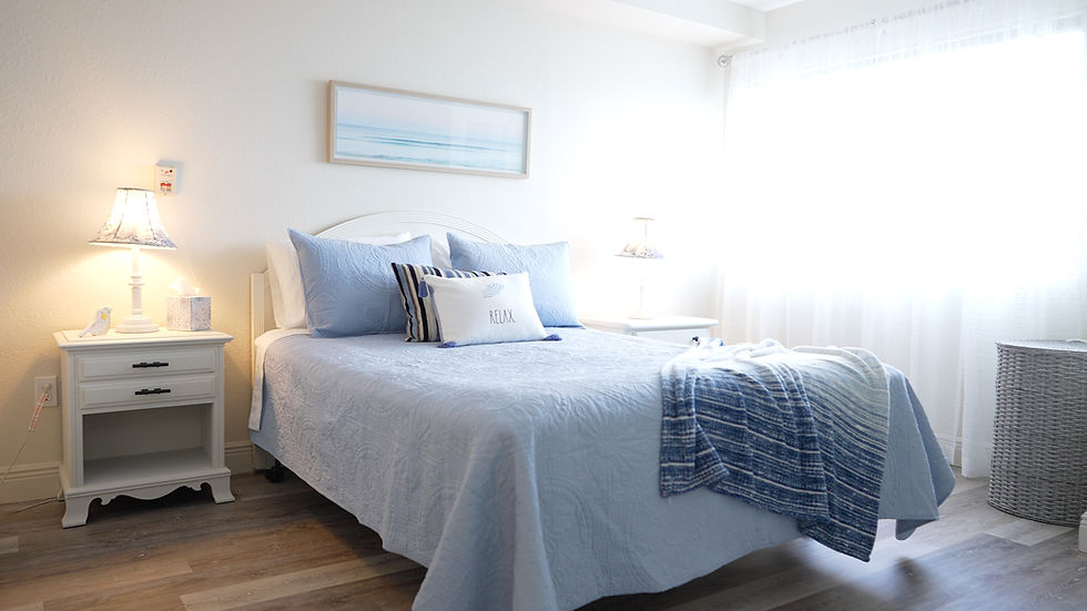 A view of a warm and cozy private suite bedroom with sunlight coming in from the window at Victoria Landing where guests can stay while they visit their loved ones.