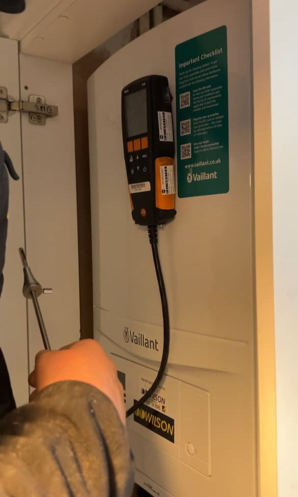 Enginer conducts a performance test on a Vaillant boiler to ensure safety and efficiency.