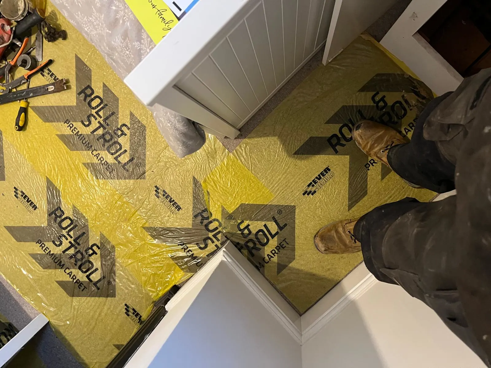 Landing staircase covered in roll and straight stroll film protection for the carpet.