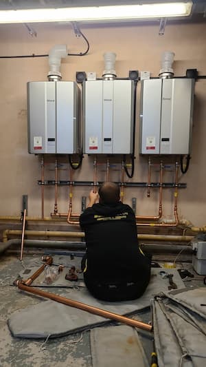 Housing Association Plant Room Upgrade Team Working On Boiler