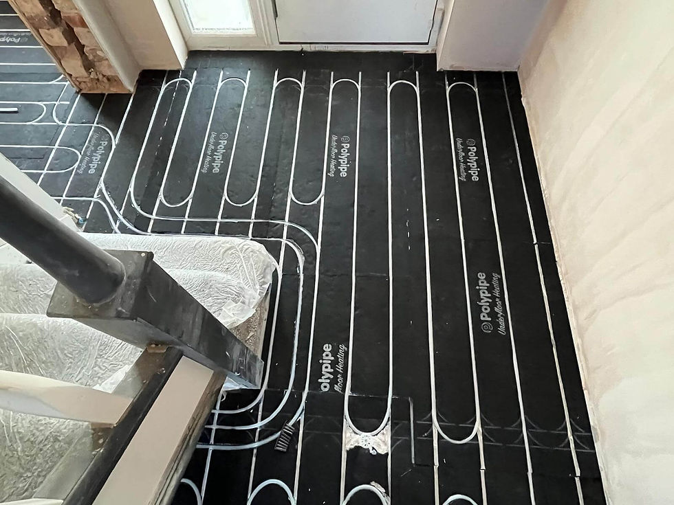 Black floor with white heating pipes labeled "Polypipe" in a room with stairs and a door. Light and clean modern setup.