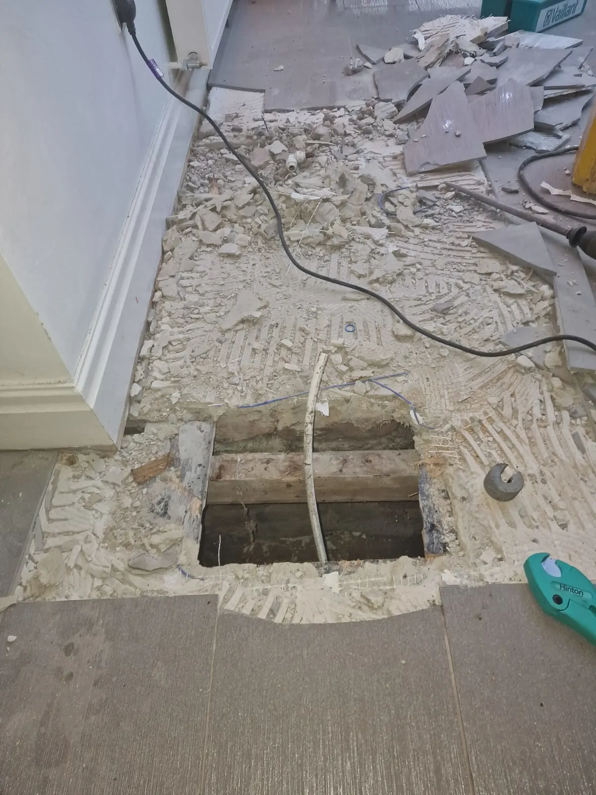 Hole in kitchen floor when the team has dug in to stop the leak underneath the house.