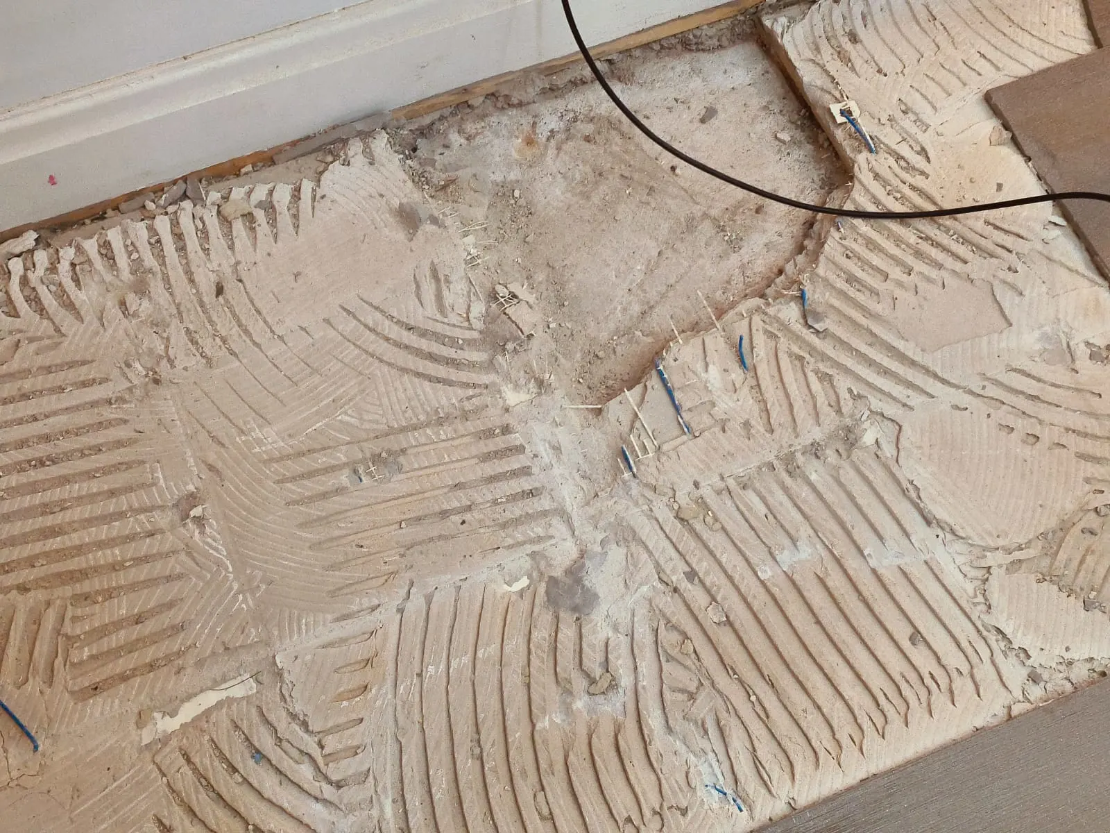 Image shows where tiles have been dug up to expose a hole where the leak potentially was.