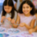 Two girls making bracelets as a creative birthday party idea in Vancouver.