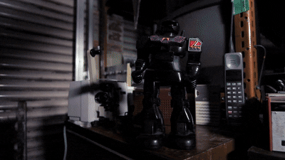 Robot giocattolo vintage nero con luce rossa.