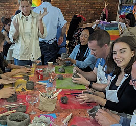 group of smiling friends painting pottery in chelsea