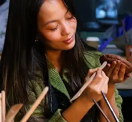 a beautiful lady shaping clay at a pottery class in chelsea