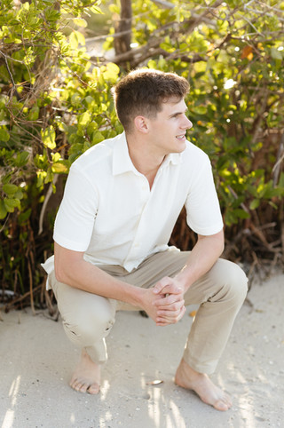 Groom posing to photographer in the sunlight in Florida