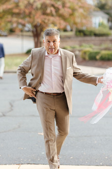 The Father of the bride making a silly face leaving a rehearsal dinner