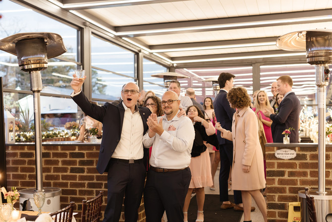 Candid moment of the guests welcoming the bride and groom at rehearsal dinner