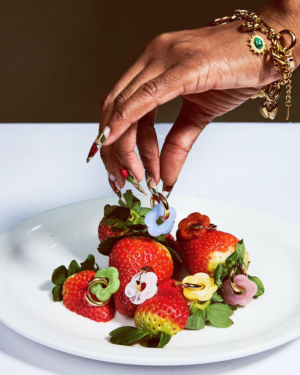 Colorful flower charm rings on fresh strawberries, playful and vibrant jewelry.
