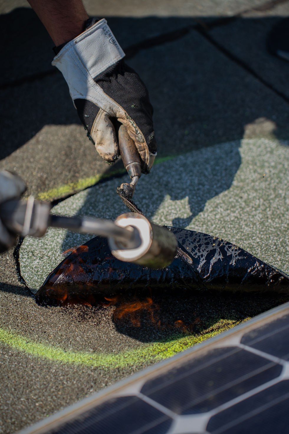 Bitumenbahn wird mit Brenner auf Dach verschweißt.