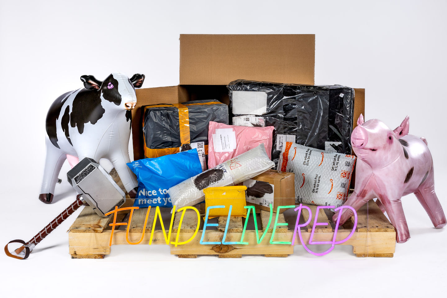 A box with several packages spilling out, a cow, thor's hammer, and a pig on a pallet