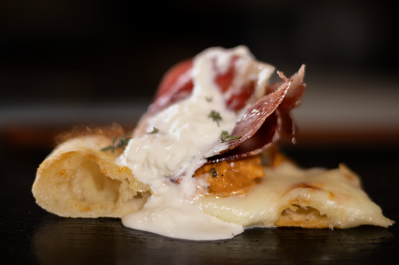 Slice of pizza with pata negra ham
