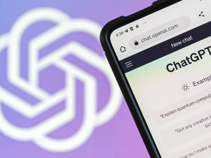 Mobile phone displaying ChatGPT interface on chat.openai.com with example prompts visible, showing the user-friendly design of the billion-user AI platform