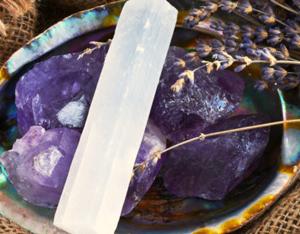 selenite stick resting in a bowl of amethyst with lavender