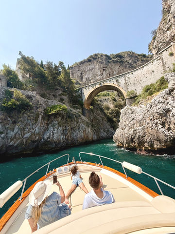 Family exploring the Amalfi Coast on a private boat tour, visiting Fiordo di Furore and the near town of Ravello