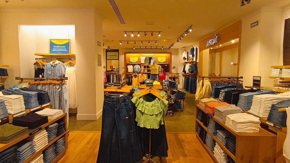 The environment is modern and relaxed, focusing on comfort and style, with plenty of clothes for sale on display.