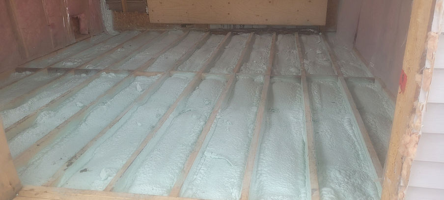 Attic floor with insulation installed; wooden beams and vapor barrier present