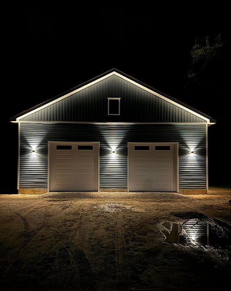 Modern two-car garage with exterior lighting at night.
