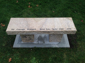 Stone memorial bench: Joy Courage Strength Brent Beta Taylor 2004 2004 on grass.