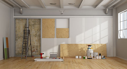 Room with exposed wall, ladder, and renovation tools