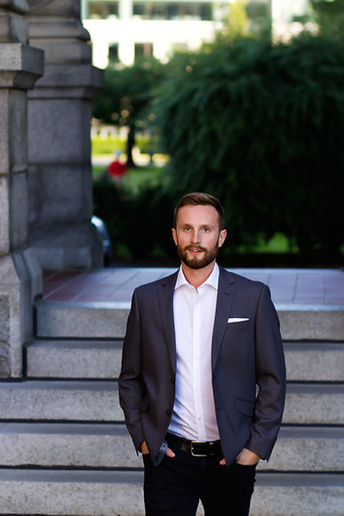 Professional man in a blazer standing on stone steps.