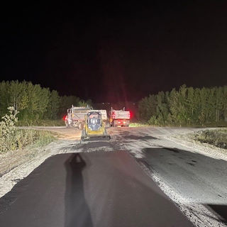 Emergency vehicles on a dark road at night, responding to an incident.